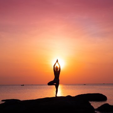 Asian girl practice Yoga on the beach Sunrise morning day